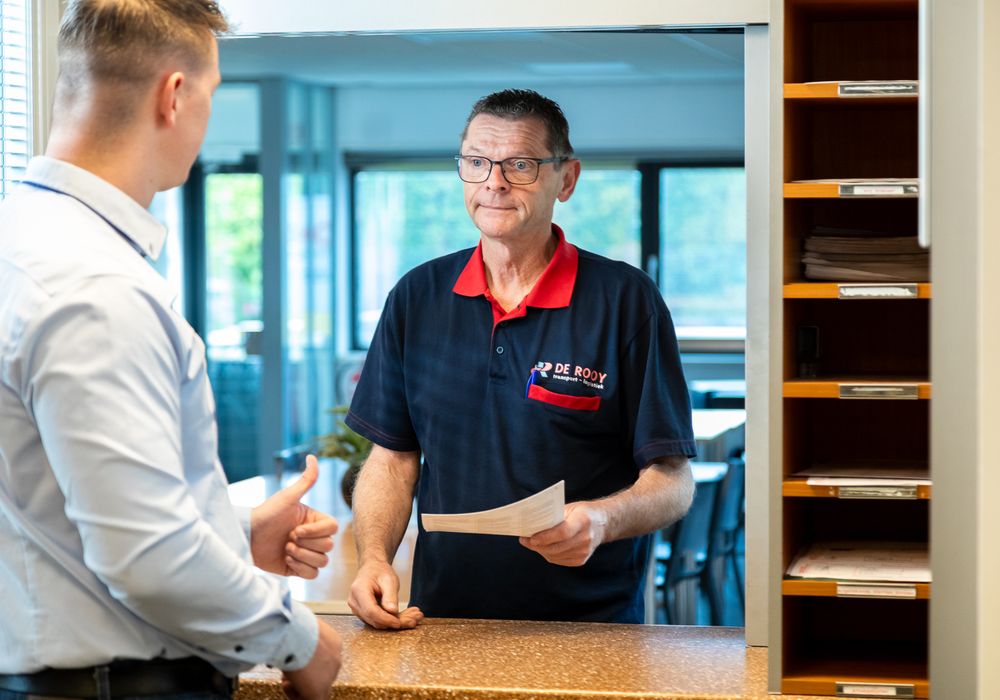 Planner geeft een chauffeur van De Rooy Transport een duim omhoog aan de balie in 't Goy