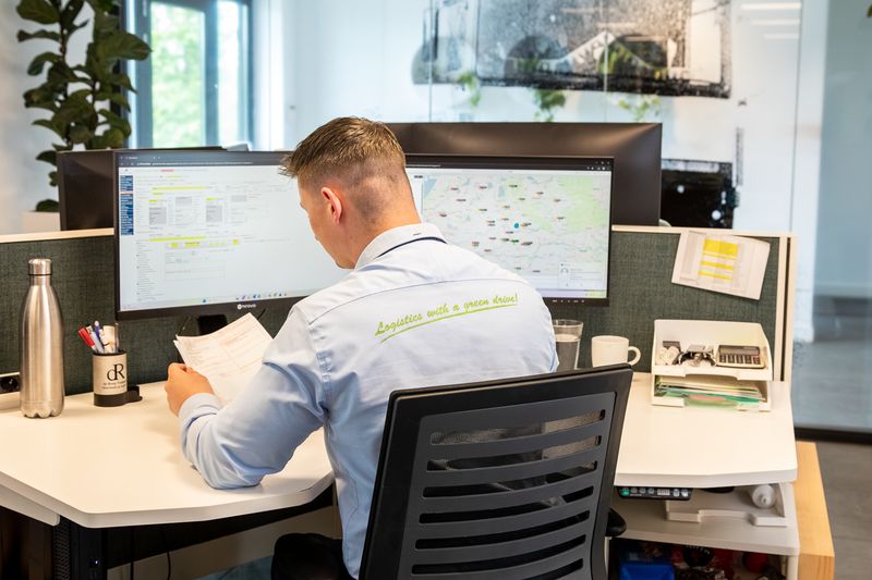 Planner van De Rooy Transport werkt aan de routeplanning met een kaart op zijn beeldscherm